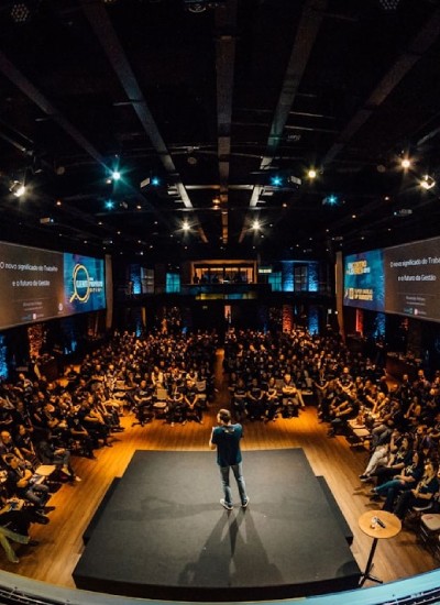 Speaker presenting to an audience at a large conference event